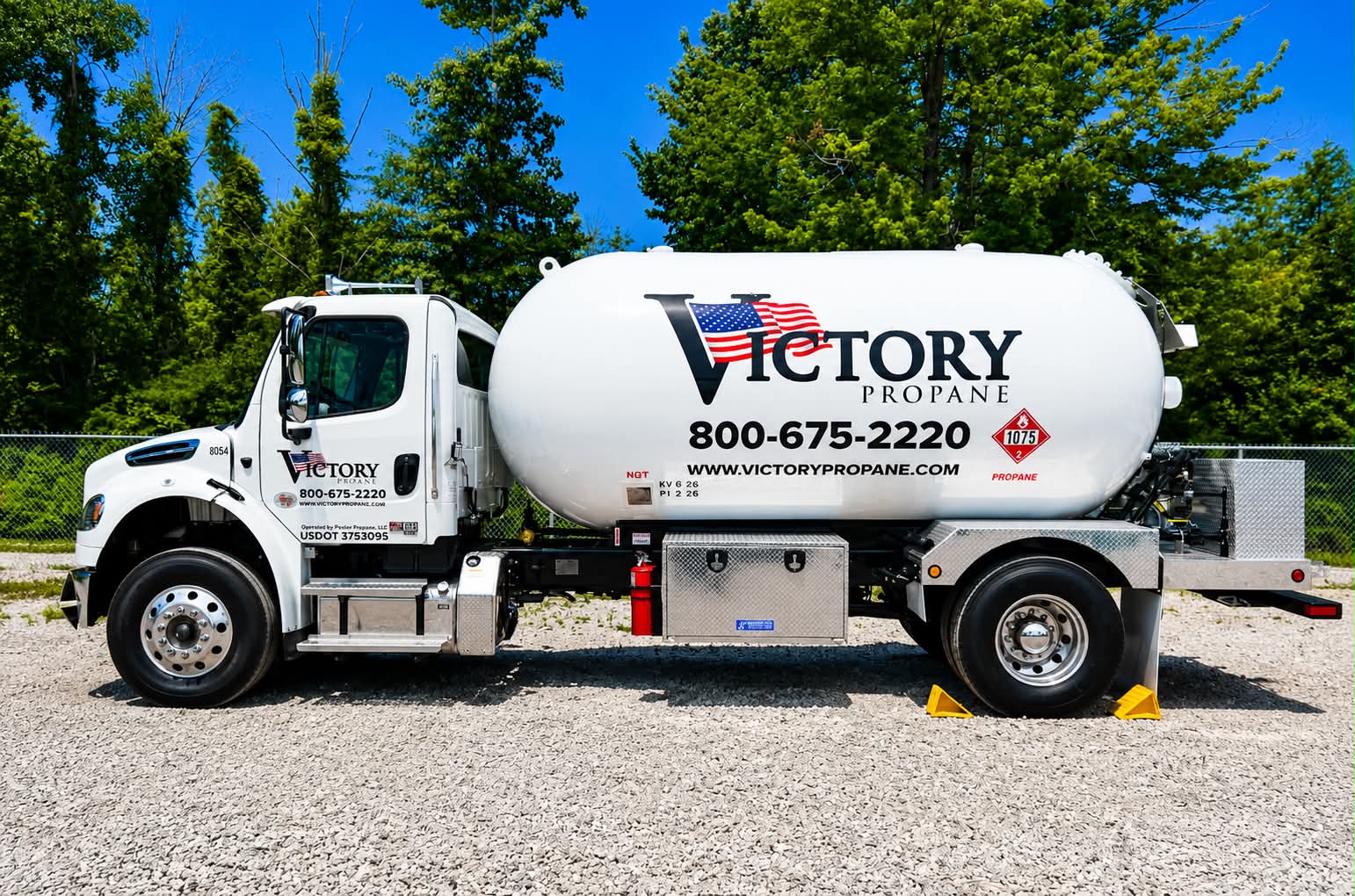 Driver-side view of a Victory Propane delivery truck with wheel chocks in place, tank lettered with phone number 800-675-2220 and www.victorypropane.com.