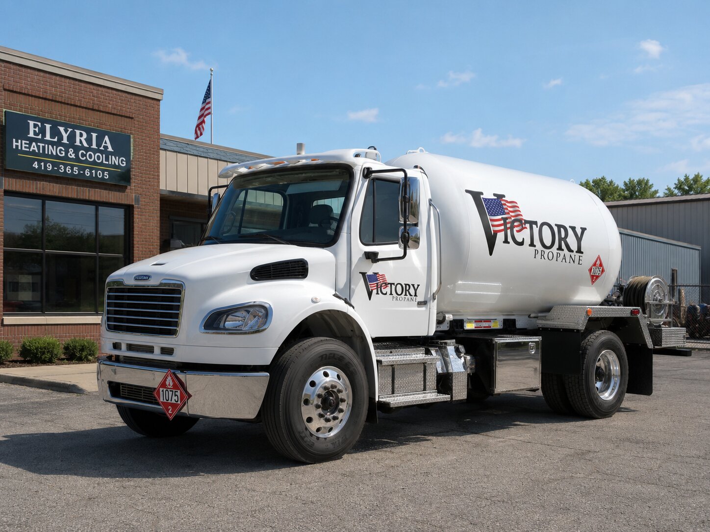Victory Propane bobtail truck parked outside Elyria Heating & Cooling, front driver-side view of the white Freightliner cab and propane tank.